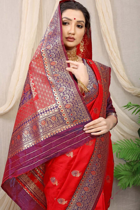 Elegant woman wearing a vibrant red Banarasi silk saree with intricate jacquard weaving and a matching blouse.